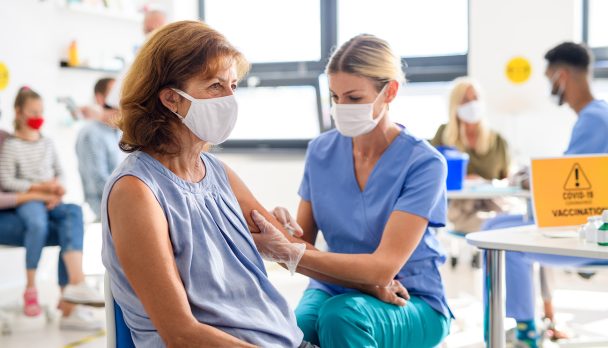 Woman with face mask getting vaccinated, coronavirus, covid-19 and vaccination concept.