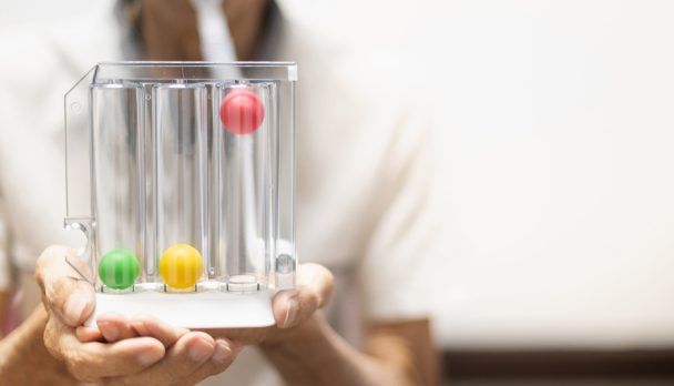 The old patient hand holding the Tri-ball incentive spirometry is medical equipment for post operation. The equipment for Lungs function testing and Pulmonary test.