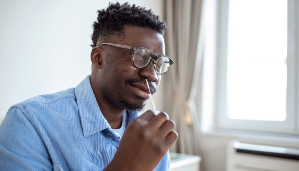 Shot,Of,A,African,Man,Using,Cotton,Swab,While,Doing