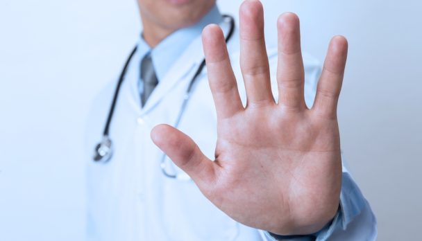 Doctor,Showing,Stop,Sign,On,White,Background